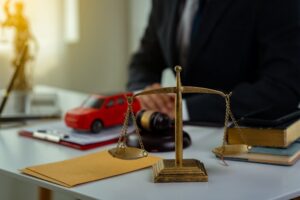 Gavel, toy car models, and legal documents in a courtroom setting, symbolizing car accident lawyer services and claims.