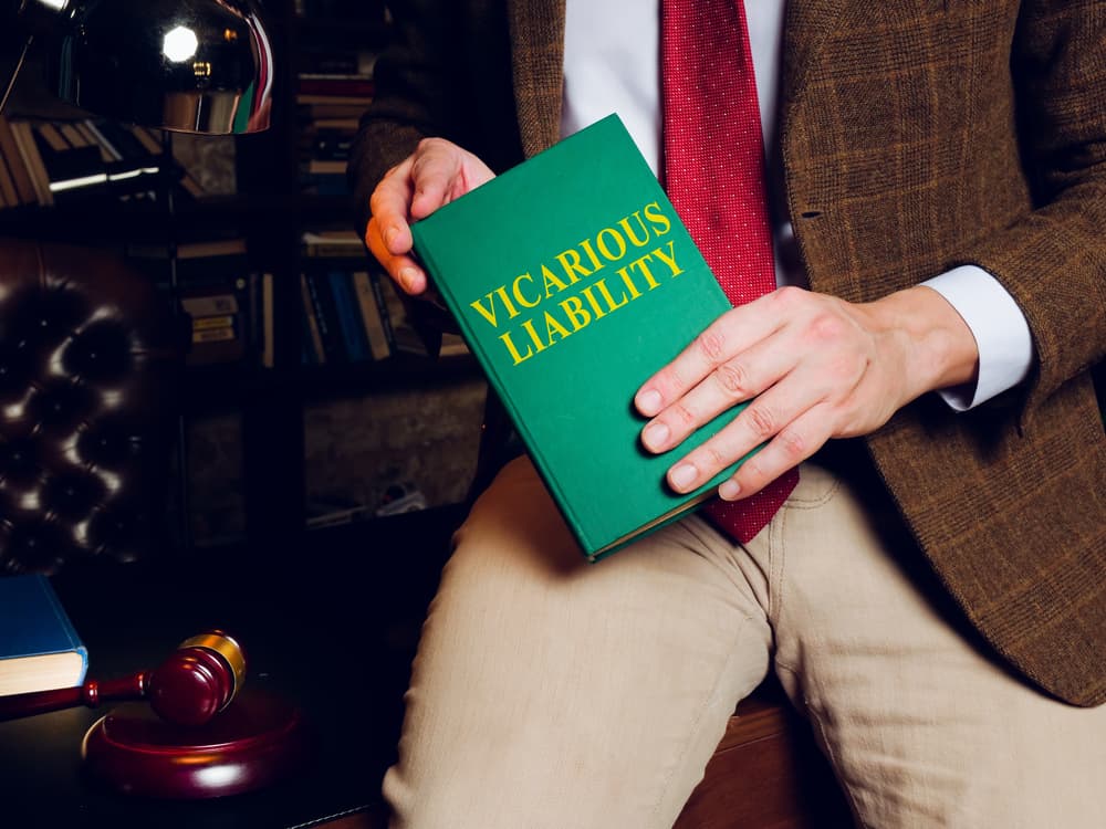An attorney holds a legal book on vicarious liability.