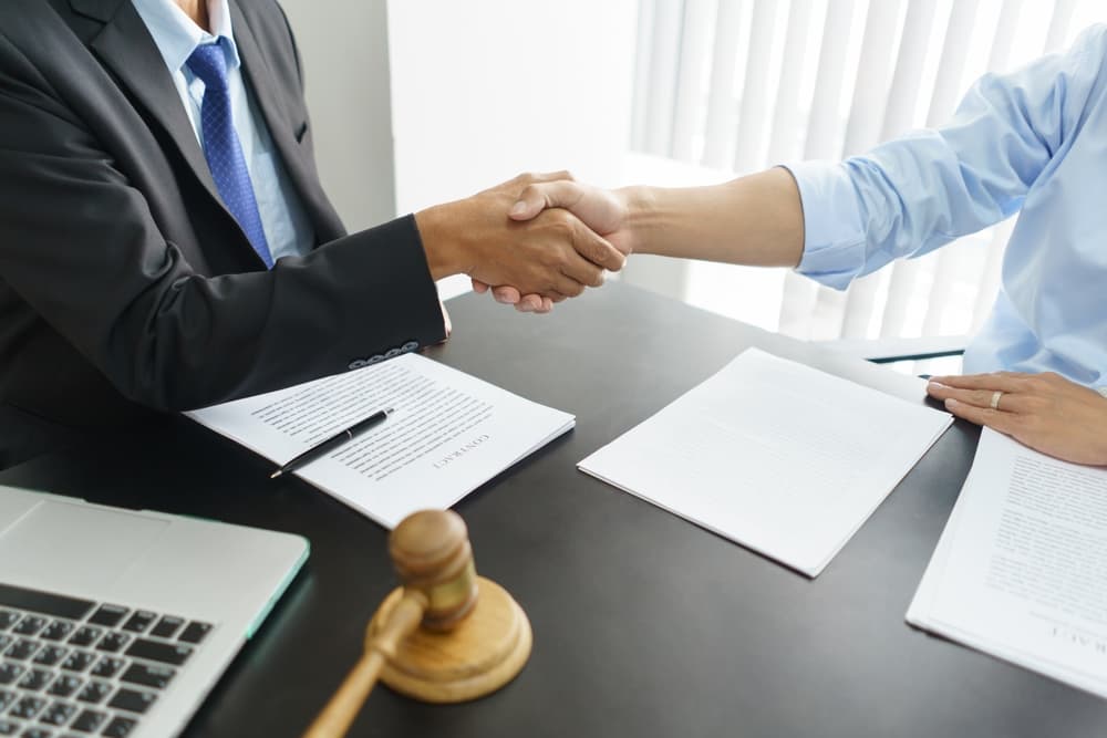 Businessman and senior lawyer shake hands after finalizing a successful legal agreement.
