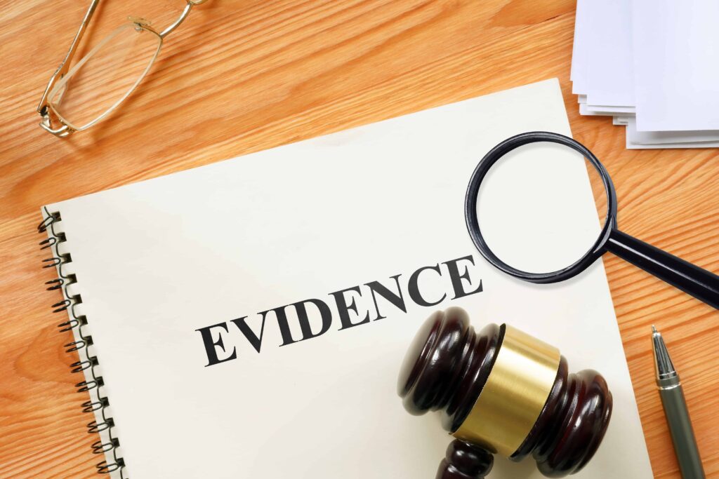 Legal evidence document with judge’s gavel and magnifying glass on desk, representing investigation and courtroom proof Legal evidence document with judge’s gavel and magnifying glass on desk, representing investigation and courtroom proof